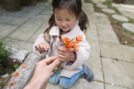 Foto de Las manos de los padres y los niños con las flores de amapola - Imagen libre de derechos