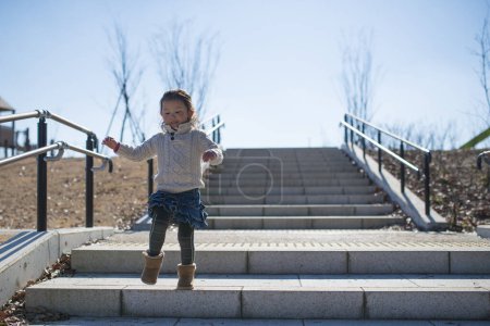 Photo for Happy child walking on stairs in the park. - Royalty Free Image