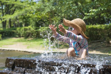 Téléchargez les photos : Petite fille pour jouer avec l'eau - en image libre de droit