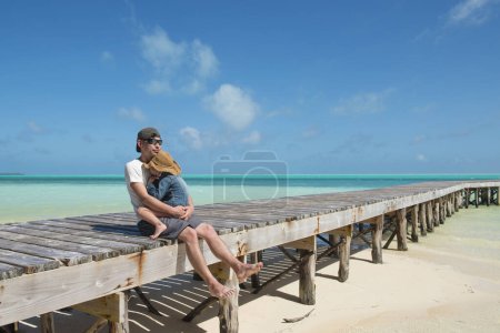 Téléchargez les photos : Père et fille se relaxant à la plage - en image libre de droit