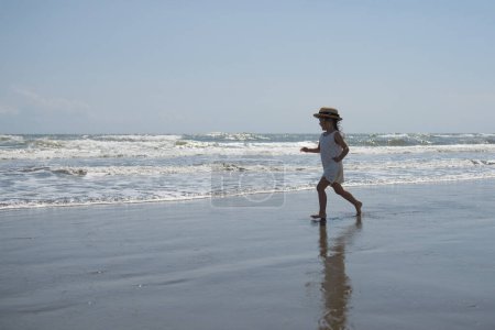 Foto de Feliz niña jugando en la playa - Imagen libre de derechos