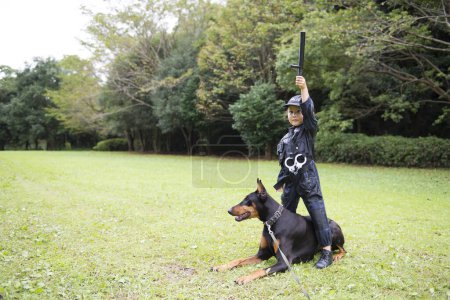 Girl wearing a police costume going on a patrol with a doberman