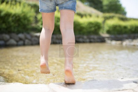 Photo for Child's feet to play with water - Royalty Free Image