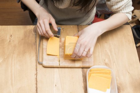 Téléchargez les photos : Femme qui a coupé le fromage - en image libre de droit