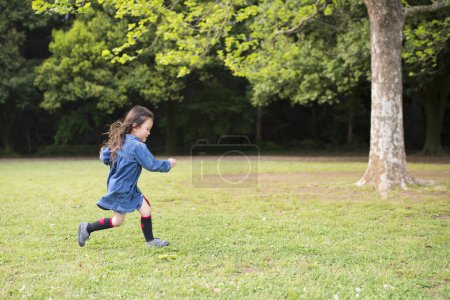 Téléchargez les photos : Fille courir sur la pelouse dans le parc - en image libre de droit