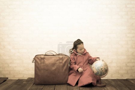 Foto de Niña con una maleta y globo en el suelo - Imagen libre de derechos