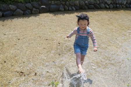 Photo for Little girl running through the stream - Royalty Free Image