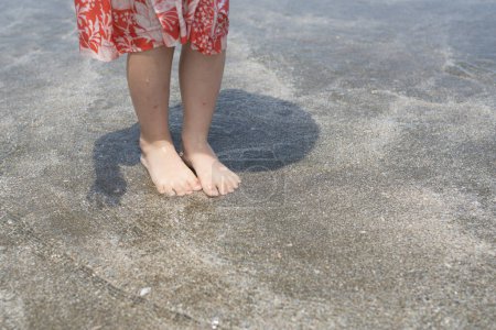 Téléchargez les photos : Pieds d'enfant dans l'eau de mer - en image libre de droit