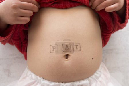 Téléchargez les photos : Enfant écrit et gros dans l'estomac - en image libre de droit