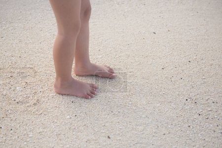 Téléchargez les photos : Pieds d'enfant jouant sur la plage - en image libre de droit
