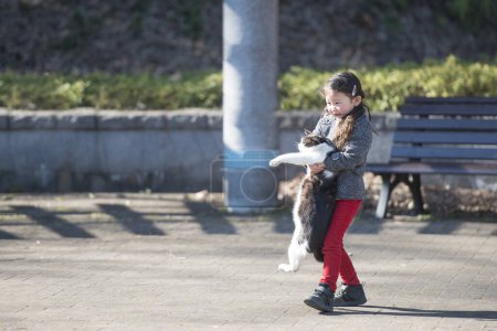 Foto de Una chica con un gato en el parque - Imagen libre de derechos