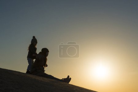 Téléchargez les photos : Silhouette mère et fille au coucher du soleil - en image libre de droit