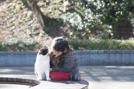 Téléchargez les photos : Petite fille jouant avec un chat - en image libre de droit