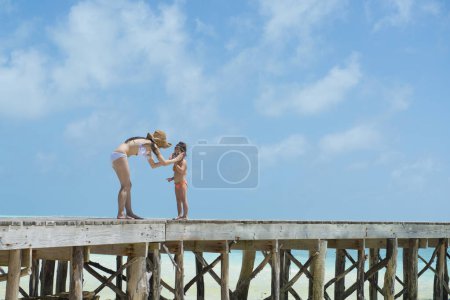 Téléchargez les photos : Parent et enfant jouant sur la jetée de l'île du sud - en image libre de droit