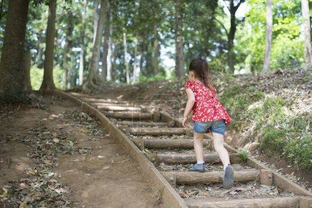 Photo for Cute asian little girl walking in the park - Royalty Free Image
