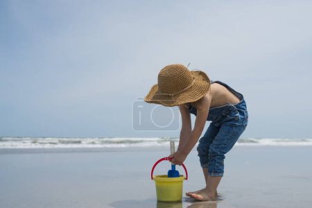 Téléchargez les photos : Petite fille jouant sur la plage - en image libre de droit