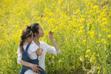Photo for Mother and daughter playing in the rape field - Royalty Free Image