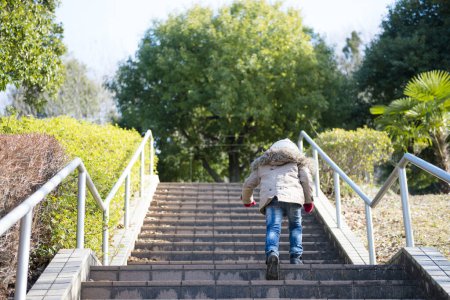 Téléchargez les photos : Petite fille monter les escaliers dans le parc - en image libre de droit