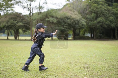 Girl wearing a police costume running on lawn