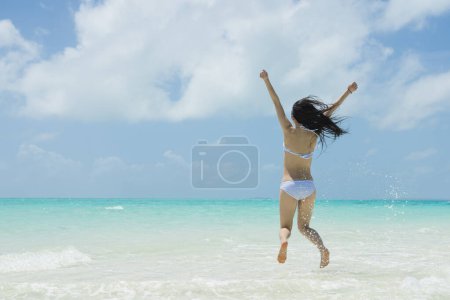 Foto de Hermosa mujer para saltar en la playa - Imagen libre de derechos