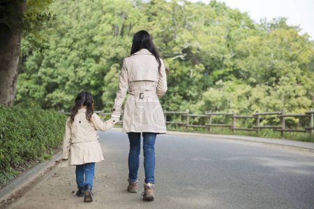 Téléchargez les photos : Mère et fille portant un manteau marchant - en image libre de droit