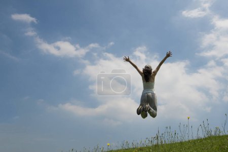 Foto de Mujer para saltar en el césped colina - Imagen libre de derechos
