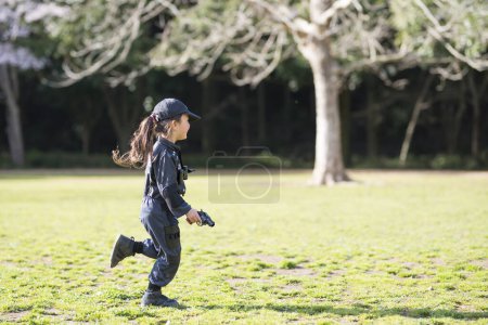 Foto de Feliz niña corriendo en traje de policía - Imagen libre de derechos