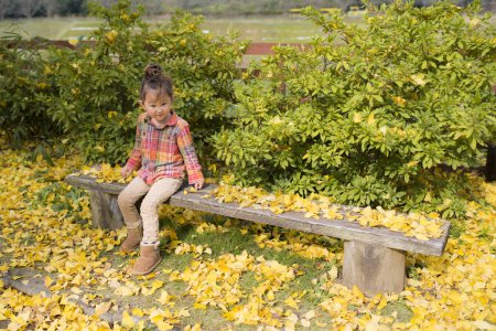 Photo for Girl sitting on a bench in the autumn park - Royalty Free Image