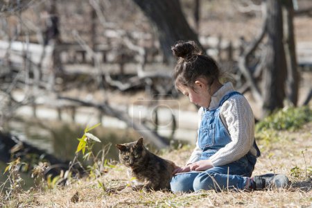 Téléchargez les photos : Petite fille jouant avec un chat - en image libre de droit