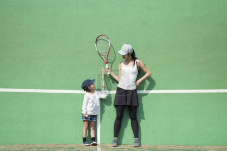 Téléchargez les photos : Mère et fille jouant au tennis - en image libre de droit