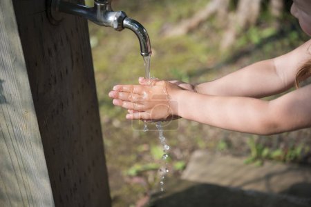 Photo for Child wash her hands outdoors - Royalty Free Image