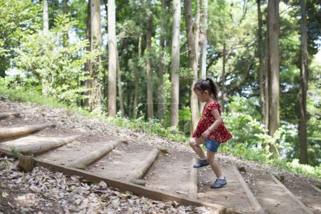 Foto de Lindo poco asiático chica caminando en el bosque - Imagen libre de derechos