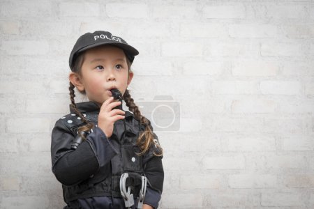 Téléchargez les photos : Fille portant un costume de police souffler le sifflet - en image libre de droit