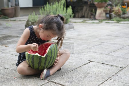 Photo for Cute little asian girl   with watermelon on the street - Royalty Free Image