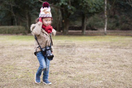Téléchargez les photos : Fille avec caméra dans le parc. saison d'hiver. - en image libre de droit