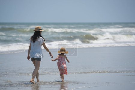 Foto de Madre e hija juegan en la playa - Imagen libre de derechos
