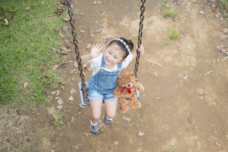 Foto de Asiático niño jugando en swing en parque - Imagen libre de derechos