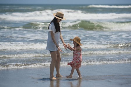 Téléchargez les photos : Mère et fille jouent sur la plage - en image libre de droit