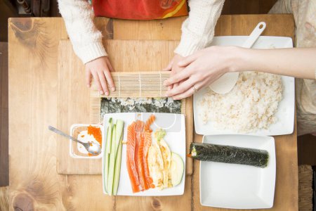 Téléchargez les photos : Mère et fille pour faire des rouleaux de sushi - en image libre de droit