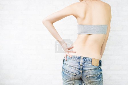 Téléchargez les photos : Vue arrière de la femme qui compte sur la hanche - en image libre de droit