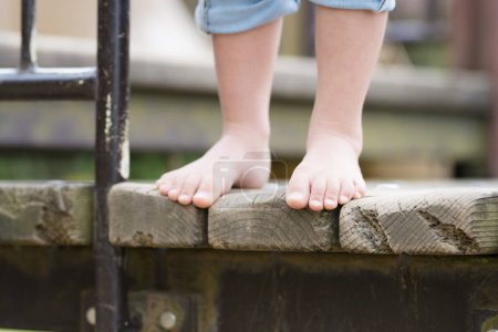 Téléchargez les photos : Bonne petite fille jouant pieds nus - en image libre de droit