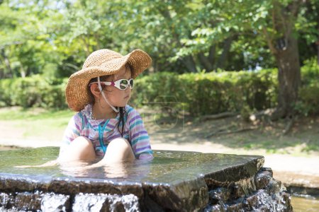 Photo for Cute little asian girl  in river  in the park - Royalty Free Image