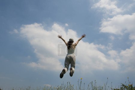 Foto de Mujer para saltar en el césped colina - Imagen libre de derechos
