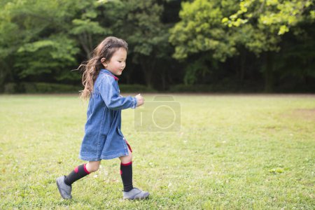 Foto de Asiático niña corriendo en parque - Imagen libre de derechos