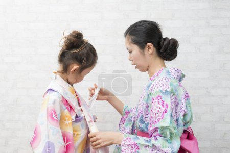 Foto de Madre e hija al aderezo de yukata - Imagen libre de derechos
