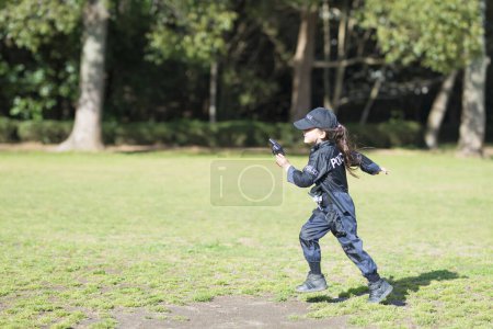 Téléchargez les photos : Bonne petite fille courir en costume de police - en image libre de droit