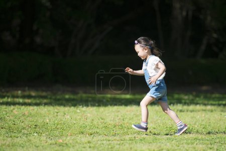 Téléchargez les photos : Petite asiatique chinois fille jouer dans l 'parc - en image libre de droit