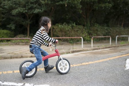 Téléchargez les photos : Asiatique fille équitation vélo dans parc - en image libre de droit