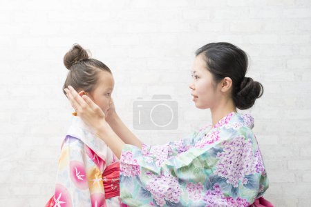 Photo for Mother and daughter to set the hair wearing yukata - Royalty Free Image