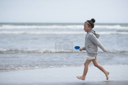 Téléchargez les photos : Mignonne petite fille asiatique jouer à la mer - en image libre de droit